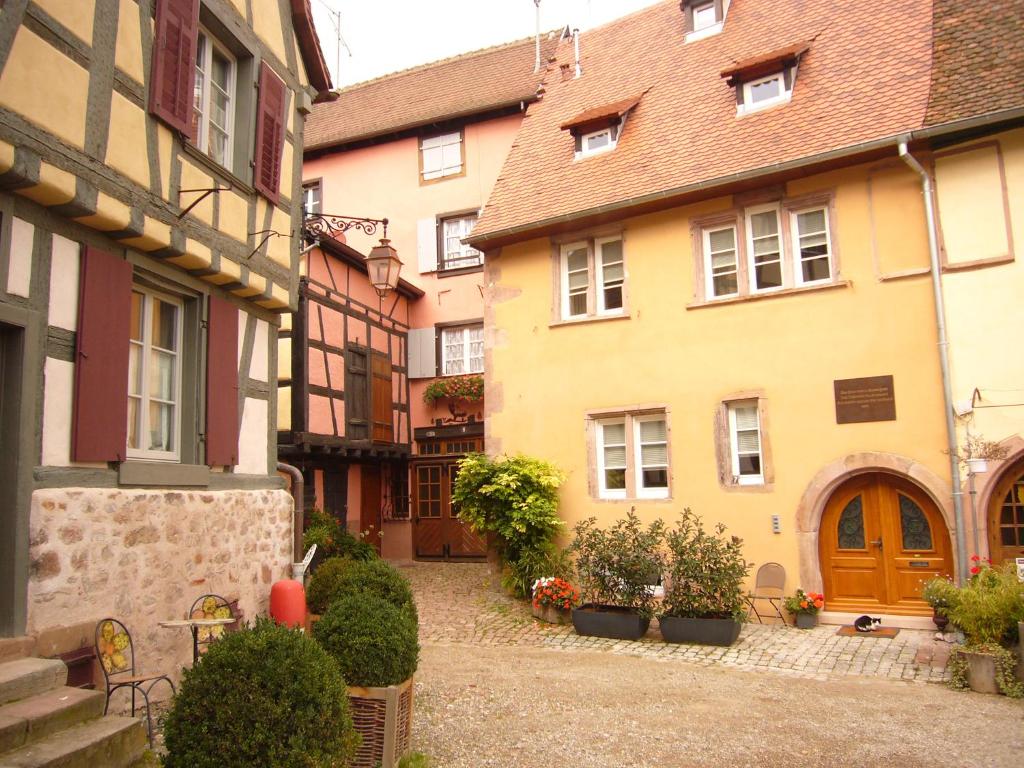 a group of buildings with plants in a courtyard at Maison Rebleuthof in Riquewihr
