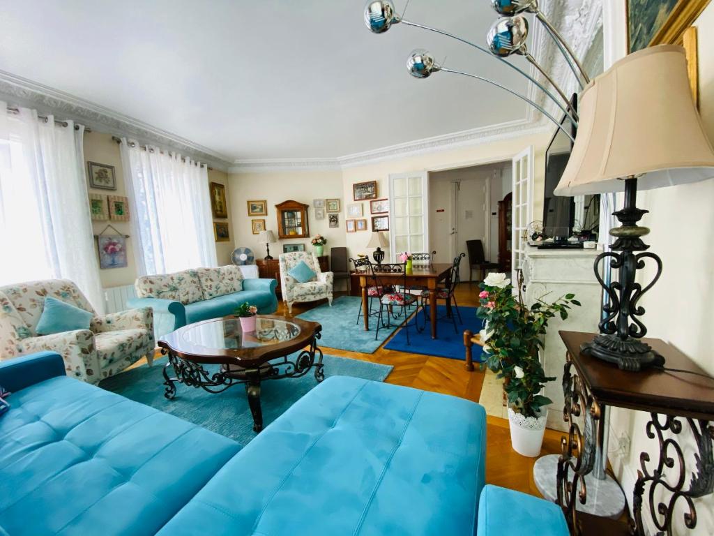 パリにあるChamps Elyséesのリビングルーム(青いソファ、テーブル付)