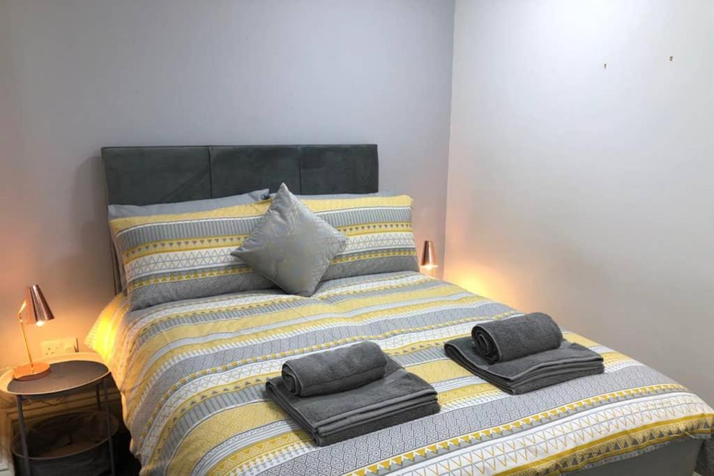 a bed with towels and pillows on top of it at Fishergate ApartHotel 1 - Stylish City Centre Apartment in Preston