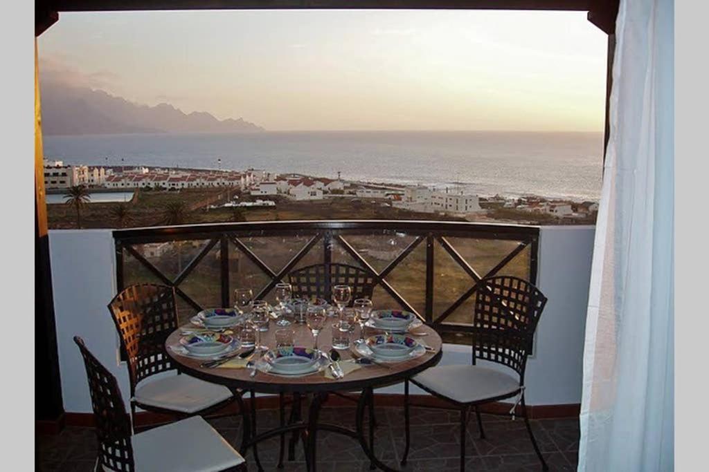 einen Tisch und Stühle auf einem Balkon mit Meerblick in der Unterkunft Casa Rosita in Agaete