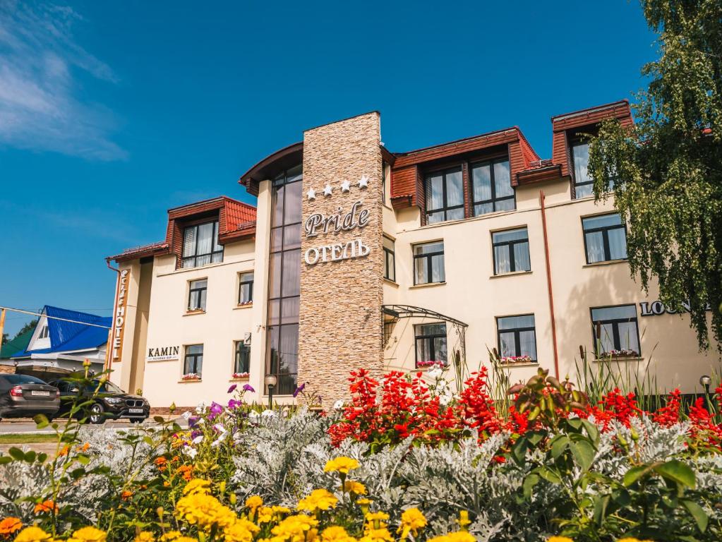 a hotel with flowers in front of it at Pride-Hotel in Berezniki