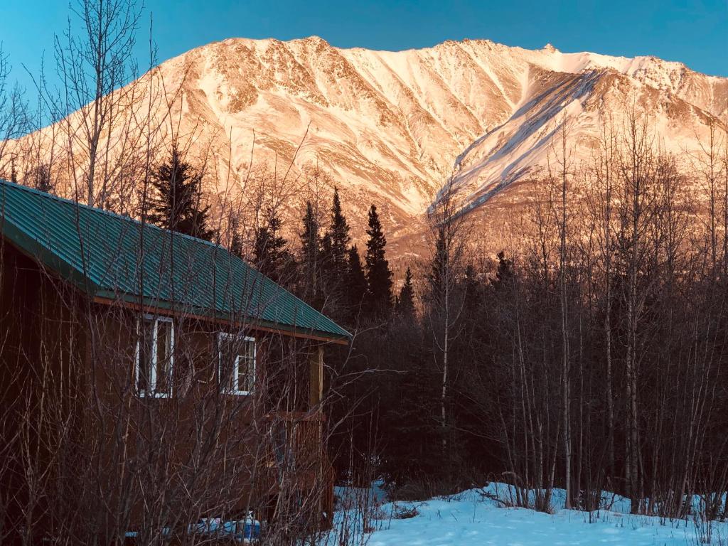 a building in front of a snow covered mountain at Wrangell Mountain Lodge- Private Bathroom with shower in McCarthy