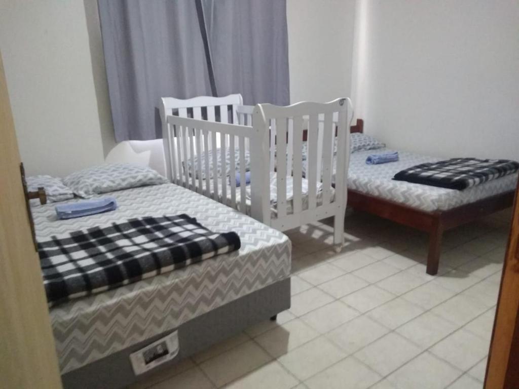 two twin beds in a room withthritisthritisthritisthritisthritisthritisbestosbestosbestos at Santo Ivo in Aparecida