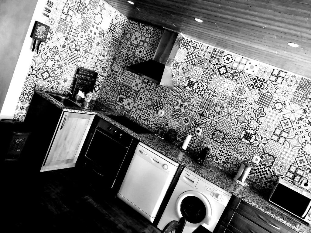 a kitchen with a sink and a washing machine at The Maggie Farm in Aranhas