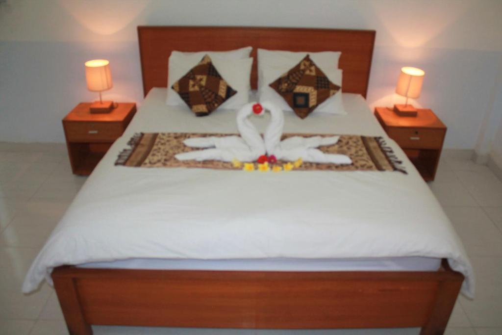 um quarto com uma cama com dois candeeiros nas laterais em Blue Royal Amed em Amed