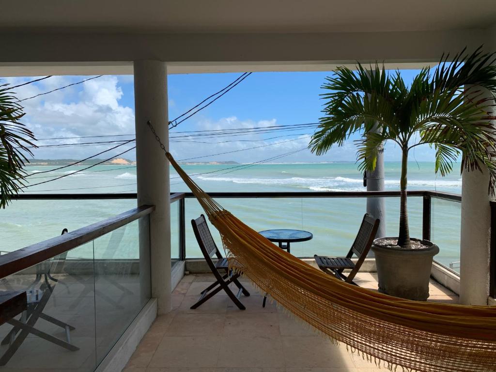 a hammock on a balcony with a view of the ocean at Casa Praia da Pipa in Pipa
