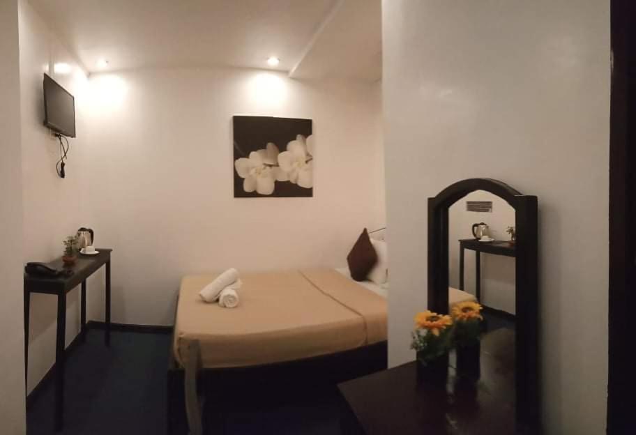 una piccola camera con letto e specchio di Amax Inn Cebu a Cebu City