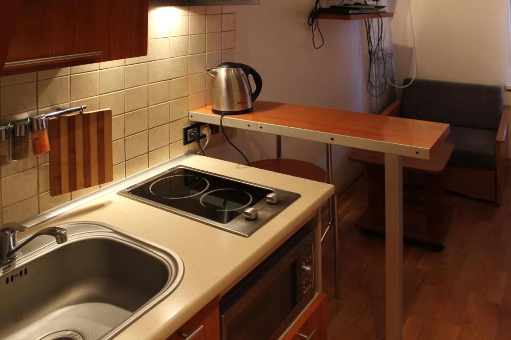 a small kitchen with a sink and a stove at Apartments On Centralny Rynok in Kaliningrad