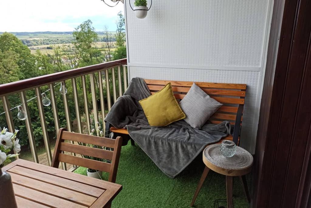 un banco con almohadas en el balcón en Studio Charmant avec vue magnifique!, en Montrichard