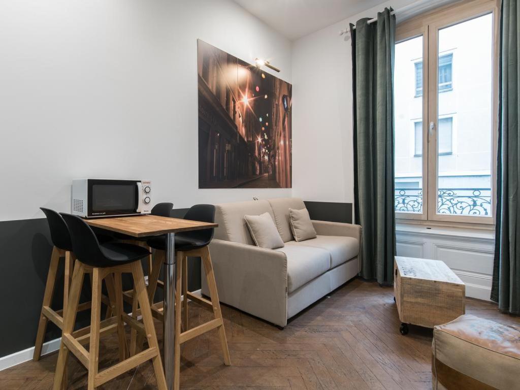 un salon avec un canapé et une table dans l'établissement Centre/Place Jaurès * Studios MyCityHome * Mezzanine, à Saint-Étienne