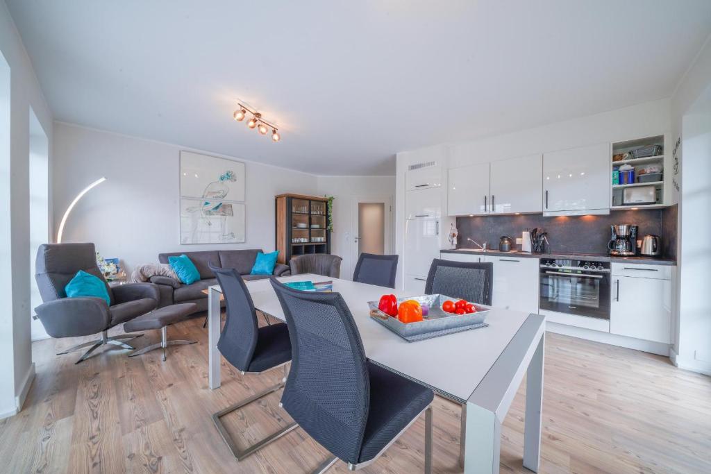 eine Küche und ein Wohnzimmer mit einem Tisch und Stühlen in der Unterkunft Südstrandhus Urlaub mit Hund Wohnung 2 unten in Borkum