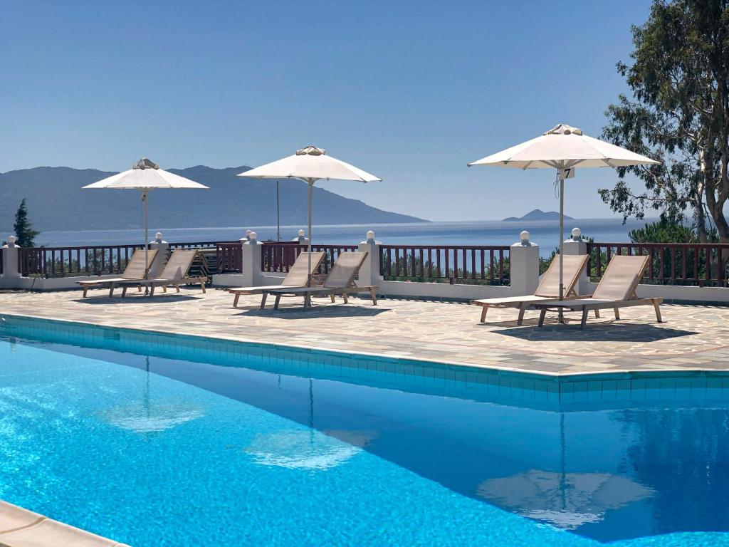 馬拉松坎博斯的住宿－Pleiades Samos，一个带两把椅子和遮阳伞的游泳池