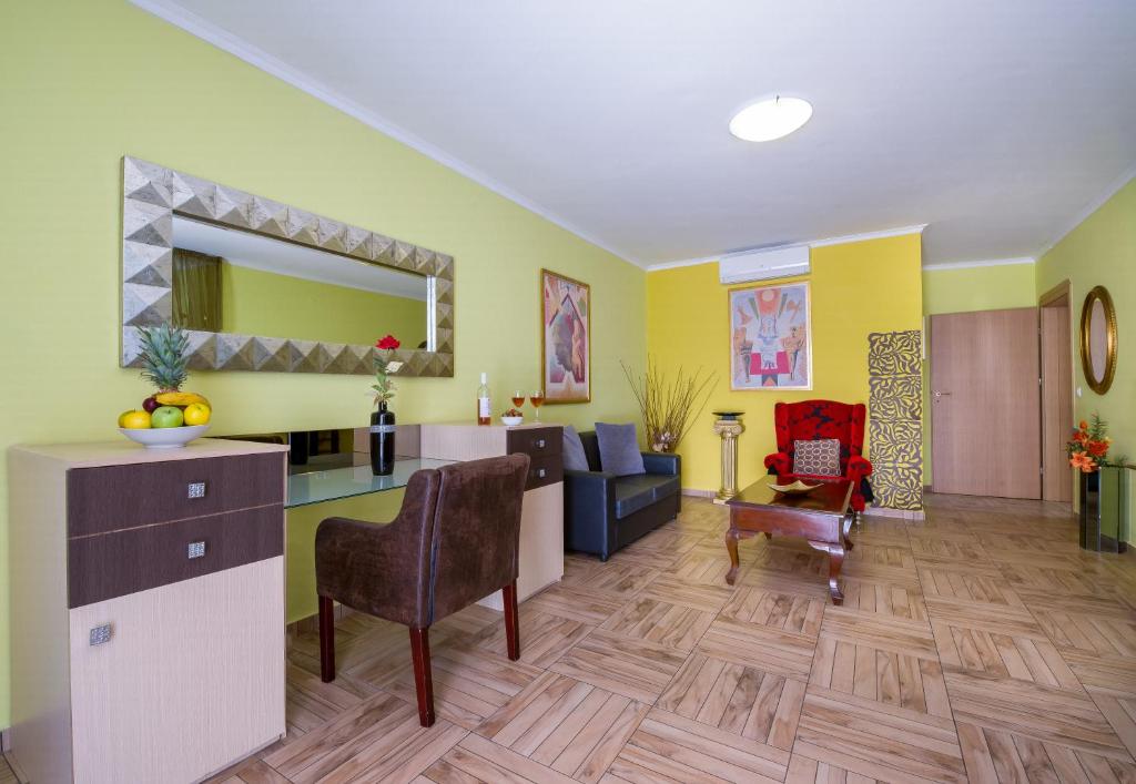 a living room with yellow walls and a dining room at Paradice Hotel Luxury Suites-Near zorbas Beach-FREE Breakfast in Stavros