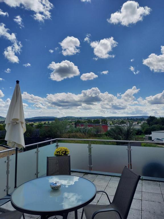 um pátio com uma mesa e cadeiras numa varanda em Ferienwohnung Schwarzwald-Baar Blick em Donaueschingen