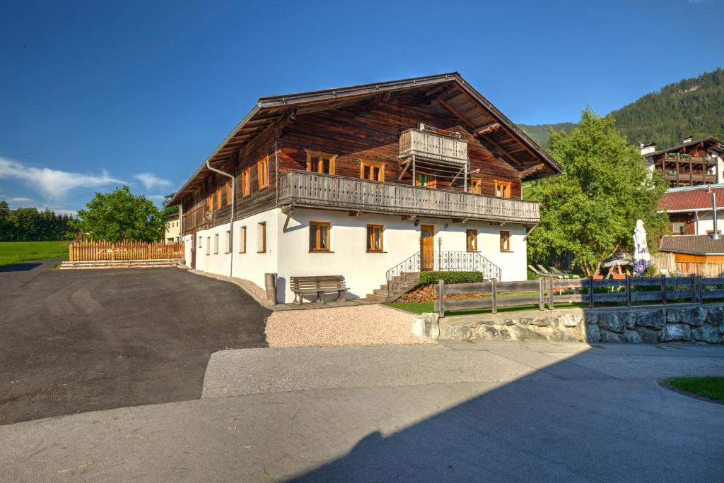 a large house with a wooden roof on a street at Chalet Rastenhof - Urlaub auf dem Bauernhof in Österreich in Gallzein