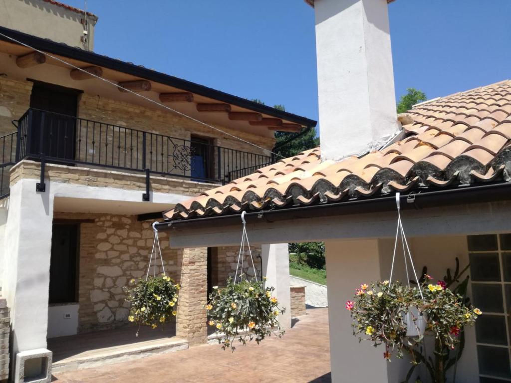 una casa con dos cestas de flores a un lado. en Vacanze in collina, tra mare e monti, en Bucchianico