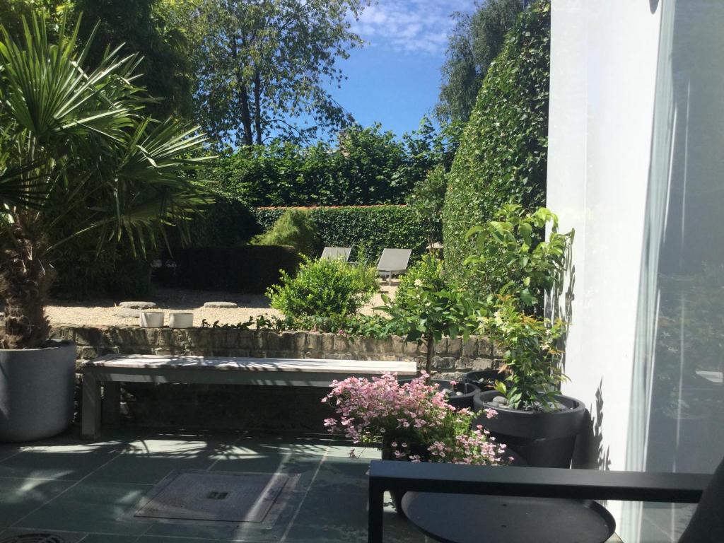 a patio with potted plants and a bench at B&B Hip in Bruges