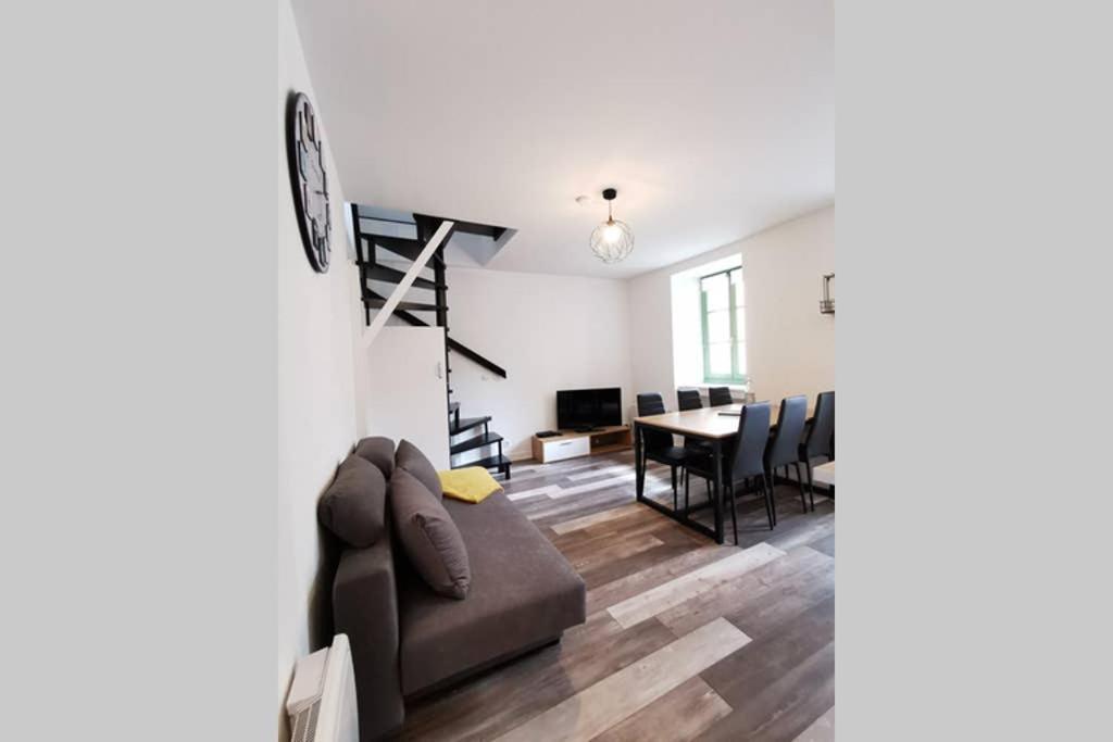 ein Wohnzimmer mit einem Sofa und einem Tisch in der Unterkunft Joli appartement maison, Dol de Bretagne, calme et lumineux, proche Mont-Saint-Michel et Saint-Malo in Dol-de-Bretagne