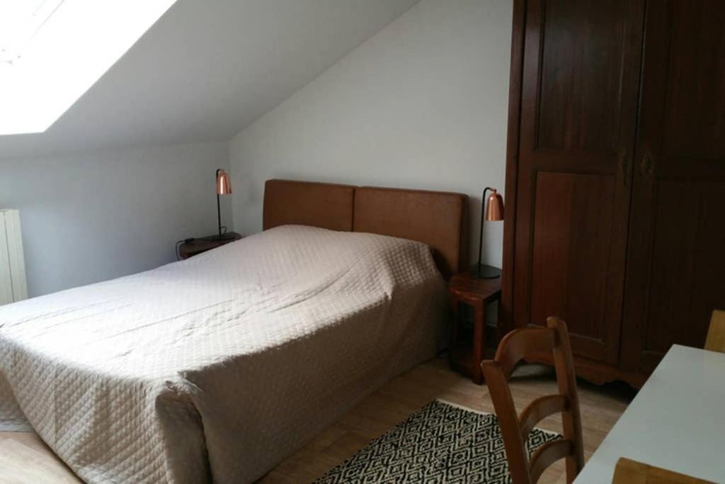 ein Schlafzimmer mit einem Bett, einem Tisch und einem Stuhl in der Unterkunft APPARTEMENT DE CHARME AU COEUR DE NEVERS in Nevers
