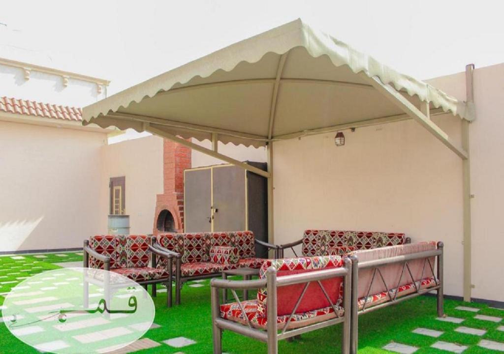 patio z krzesłami i stołem pod baldachimem w obiekcie Shams W Qamar Chalets w mieście Taif
