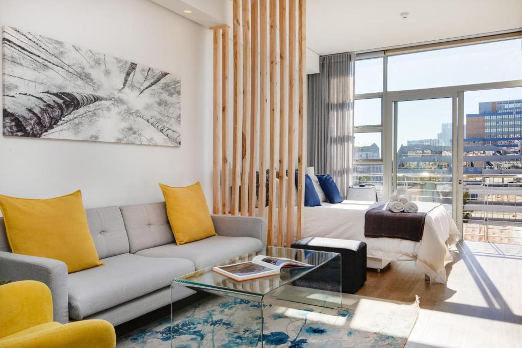 uma sala de estar com um sofá e uma mesa em Backup-Powered Trendy NY City Apartment at Table Mountain em Cidade do Cabo