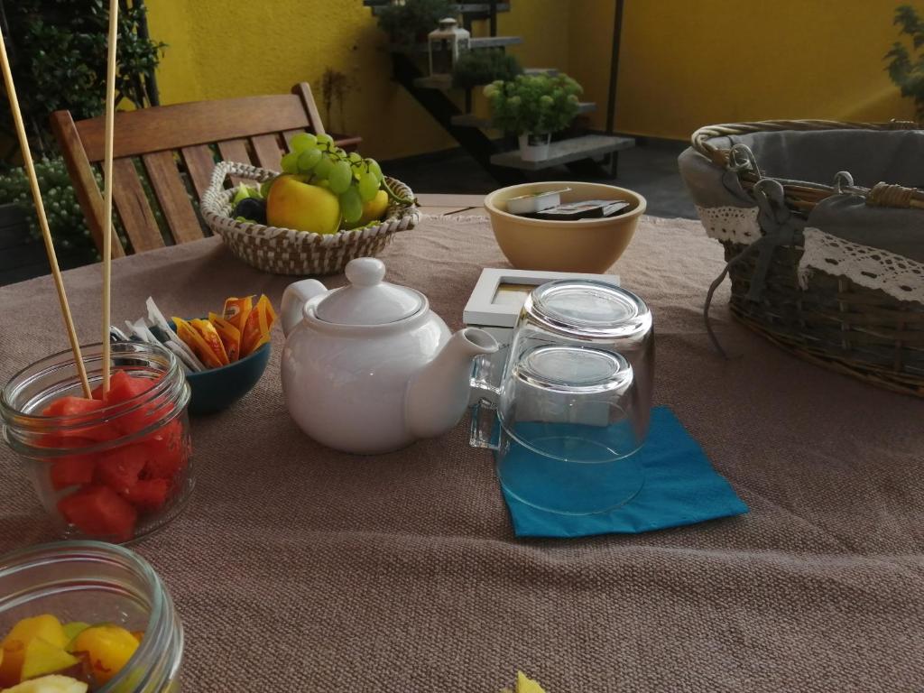 a table with fruit and a tea kettle and a basket of fruit at Il Gatto Stanco B&B in Arona