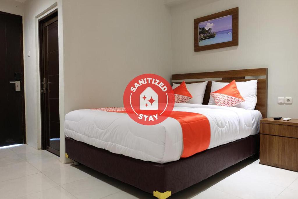 a bedroom with a bed with a sign on it at Super OYO 2756 Anata in Makassar