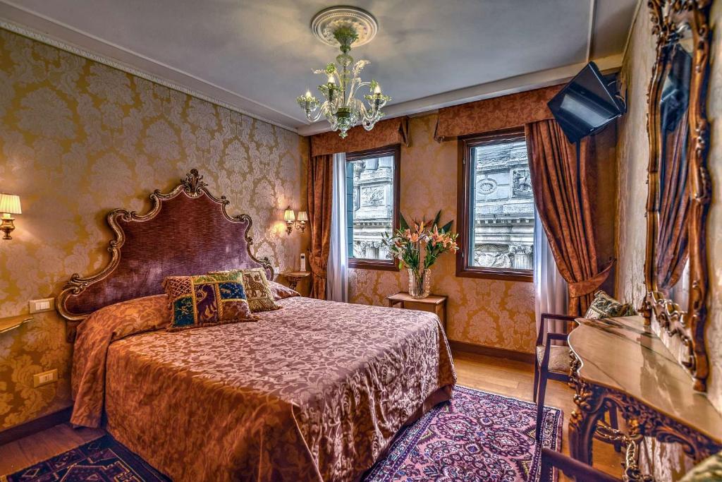 ヴェネツィアにあるHotel Bel Sito e Berlinoのベッドルーム1室(ベッド1台、シャンデリア付)