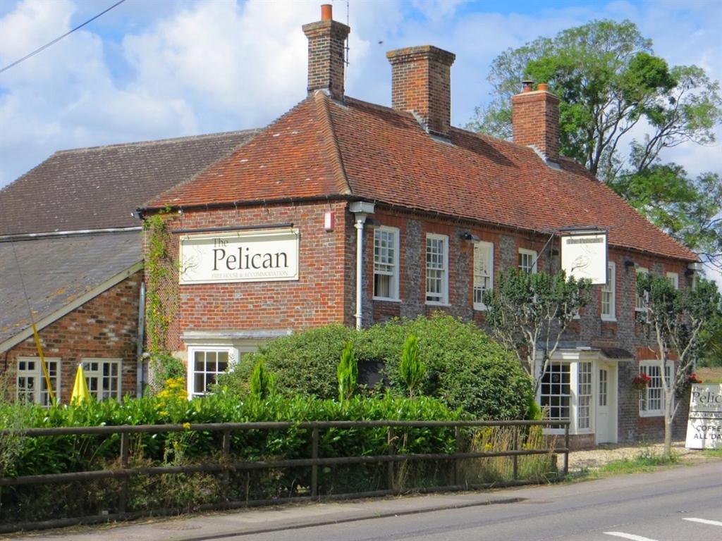 a brick building with a sign that reads pelican at The Pelican Inn in Froxfield