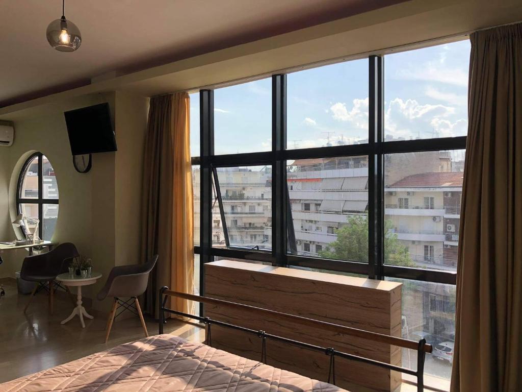 una camera da letto con una grande finestra con vista su un edificio di Loft Office House a Drama