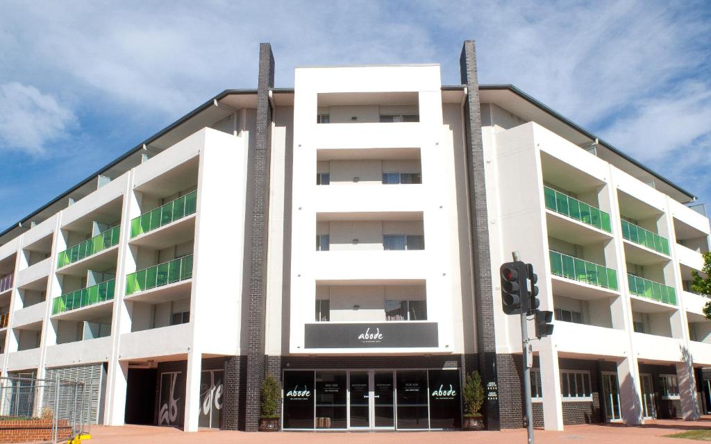 ein weißes Gebäude auf einer Straße mit Ampel in der Unterkunft Abode Tuggeranong in Canberra