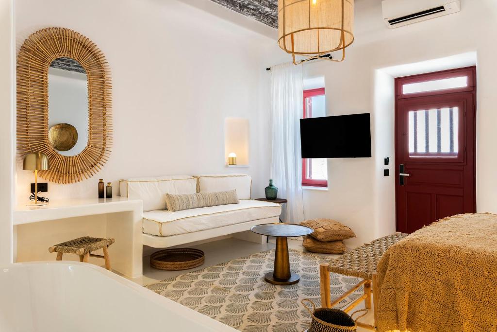 a white living room with a couch and a mirror at The TownHouse Mykonos in Mýkonos City