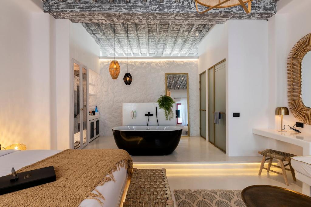 a bedroom with a bath tub in the middle of a room at The TownHouse Mykonos in Mýkonos City