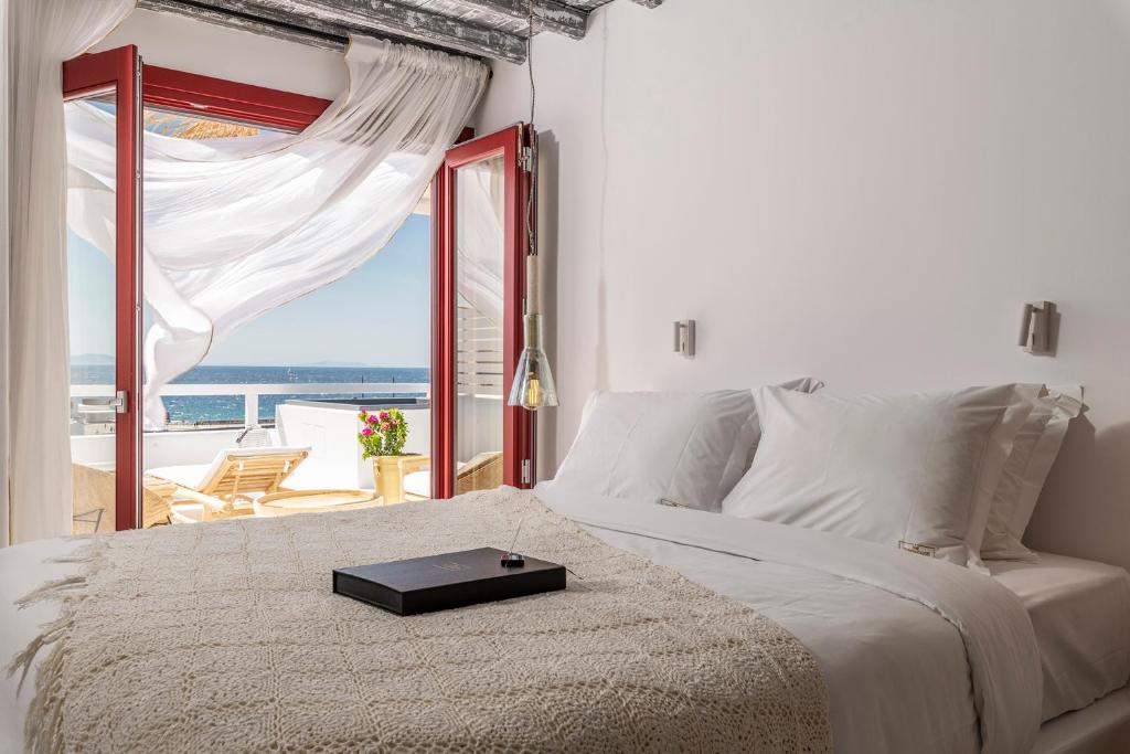 a bedroom with a bed with a view of the ocean at The TownHouse Mykonos in Mýkonos City