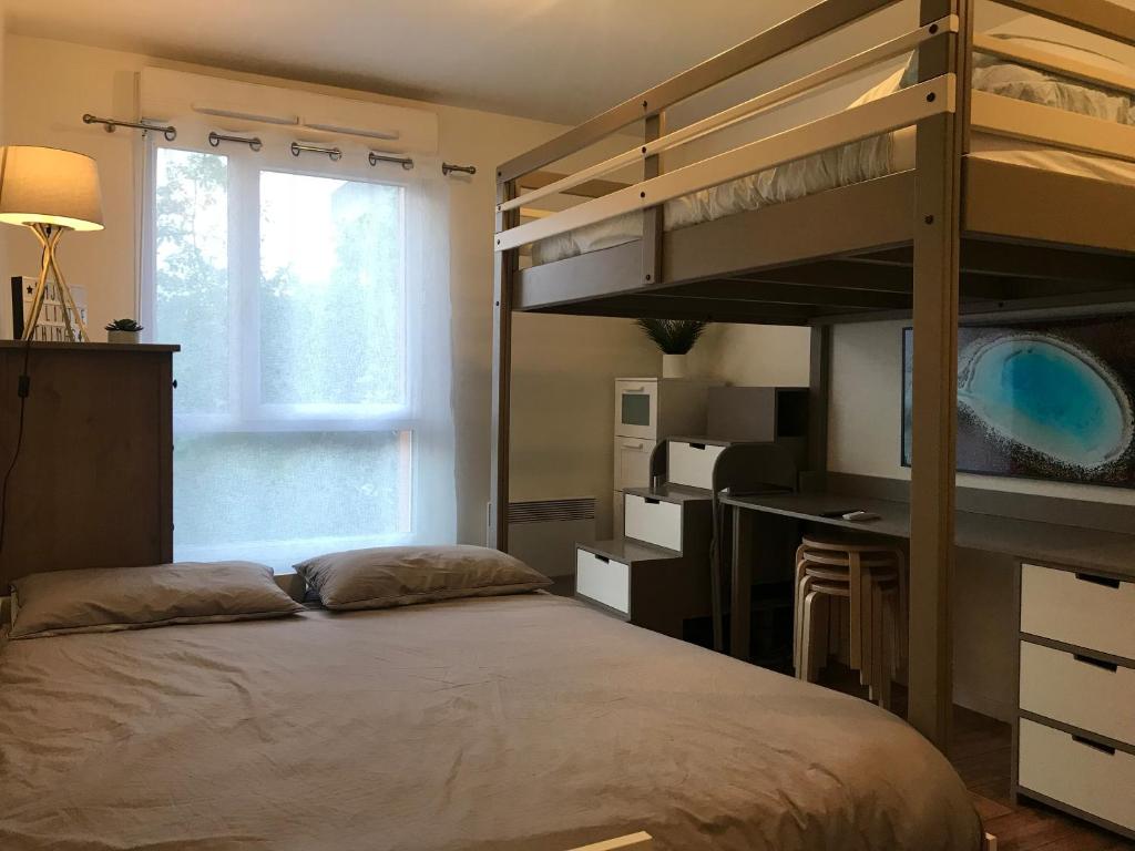 a bedroom with a bunk bed with a desk and a window at Studio 22m2 RER Val d’Europe à 150m /Disney-Paris in Montévrain