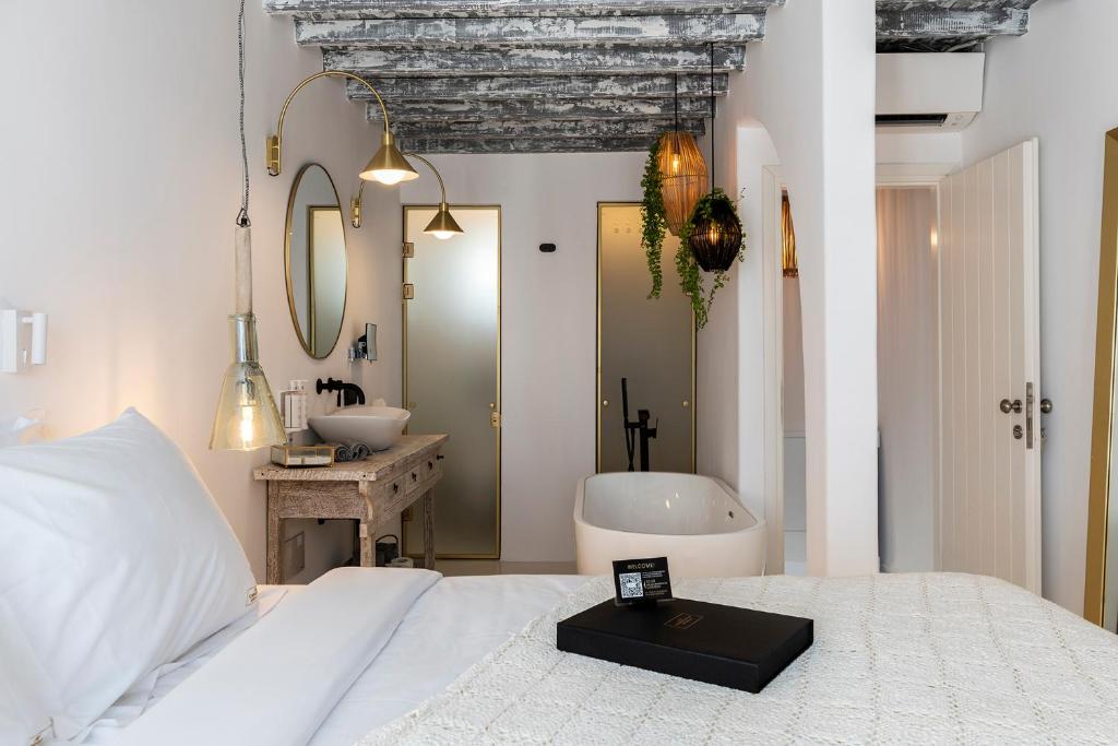 a bedroom with a bed and a tub and a sink at The TownHouse Mykonos in Mýkonos City