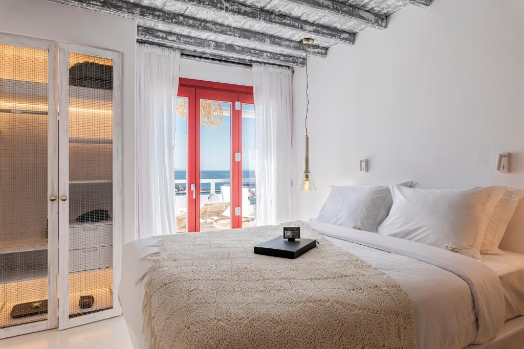 a bedroom with a bed with a view of the ocean at The TownHouse Mykonos in Mýkonos City