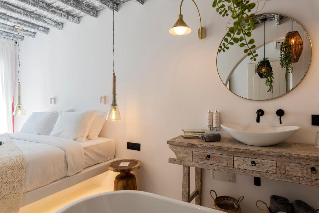 a bedroom with a bed and a sink and a mirror at The TownHouse Mykonos in Mýkonos City