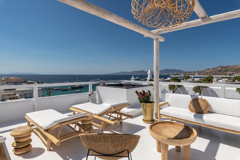 a balcony with white furniture and a view of the ocean at The TownHouse Mykonos in Mýkonos City