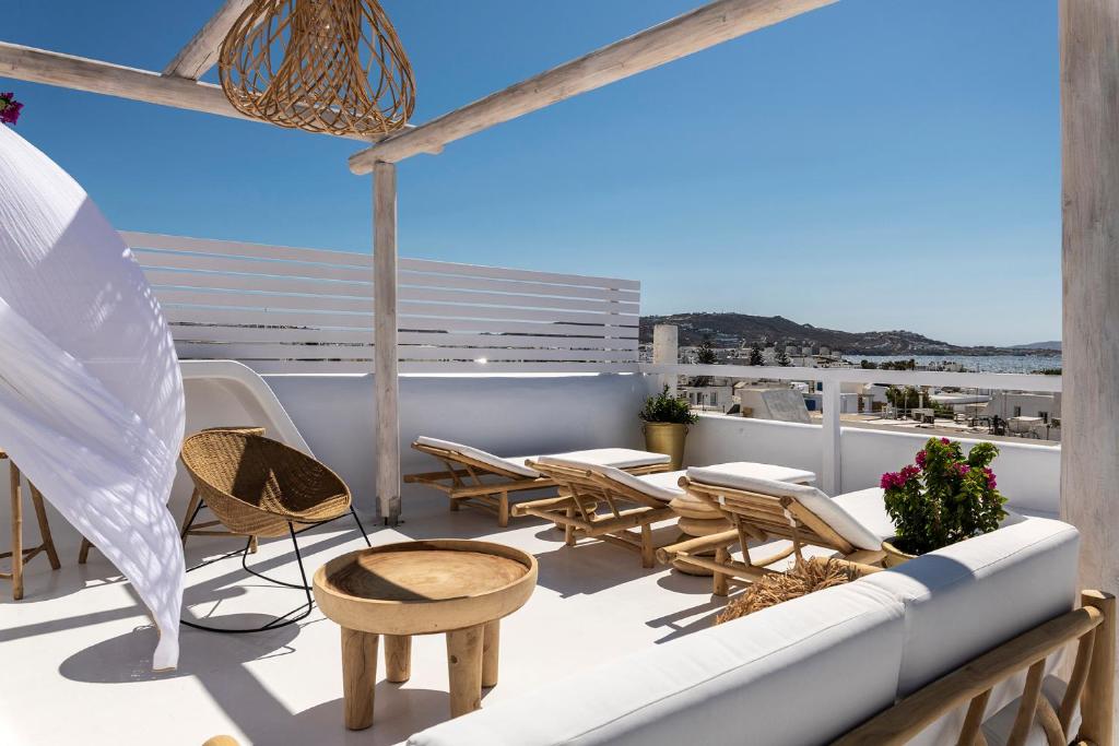 a patio with chairs and tables on a balcony at The TownHouse Mykonos in Mýkonos City