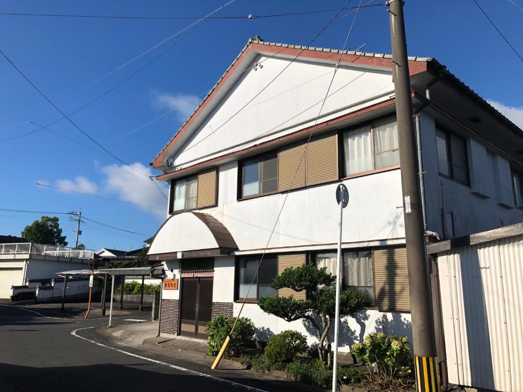 ein Gebäude an der Ecke einer Straße in der Unterkunft ゲストハウスまちかど Guest House MACHIKADO in Ibusuki