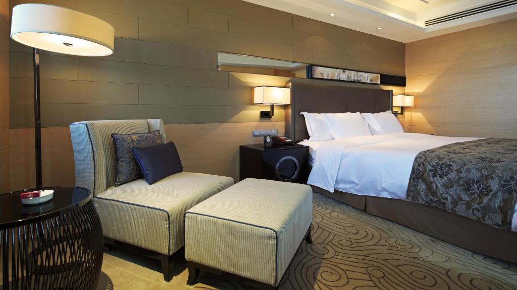 a hotel room with a bed and a chair at Crowne Plaza Xi'an by IHG in Xi'an
