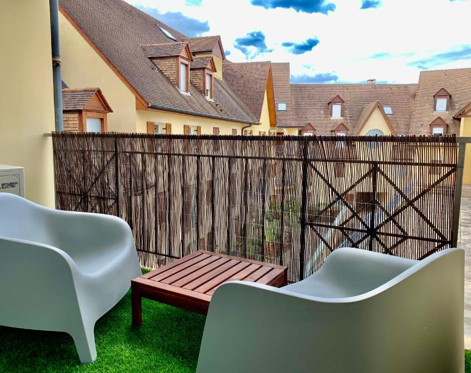 a patio with two chairs and a wooden fence at LE TROIS B in Beaune