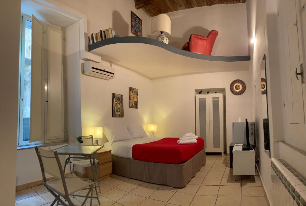 1 dormitorio con cama, mesa y TV en La Tela Bianca, en Nápoles