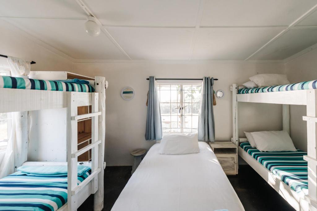 Postel nebo postele na pokoji v ubytování Umzumbe Surf House