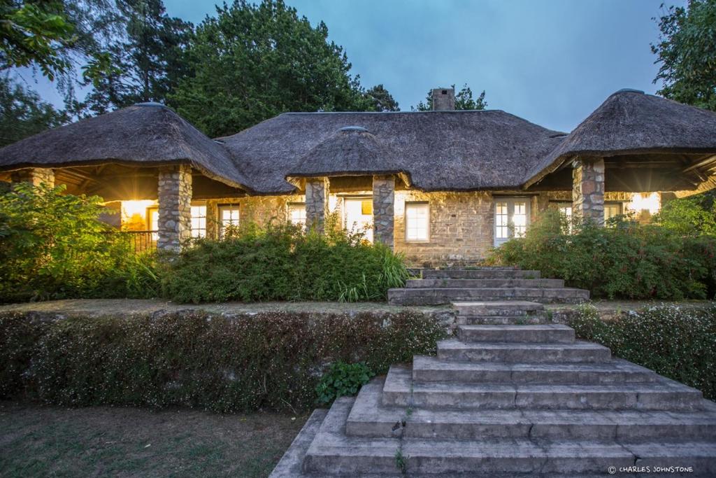 a large stone house with a thatched roof at Bredon Cottage in Hogsback