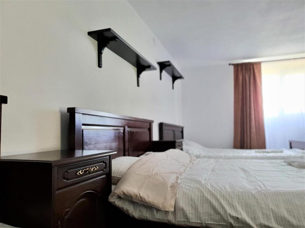 um quarto com uma cama e uma cómoda ao lado de uma janela em Casa Muscelelor em Pietroşani