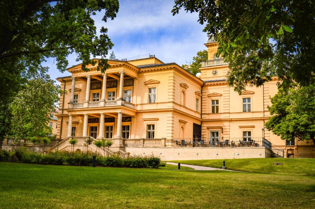 ein großes Gebäude mit Rasen davor in der Unterkunft Vila Lanna in Prag