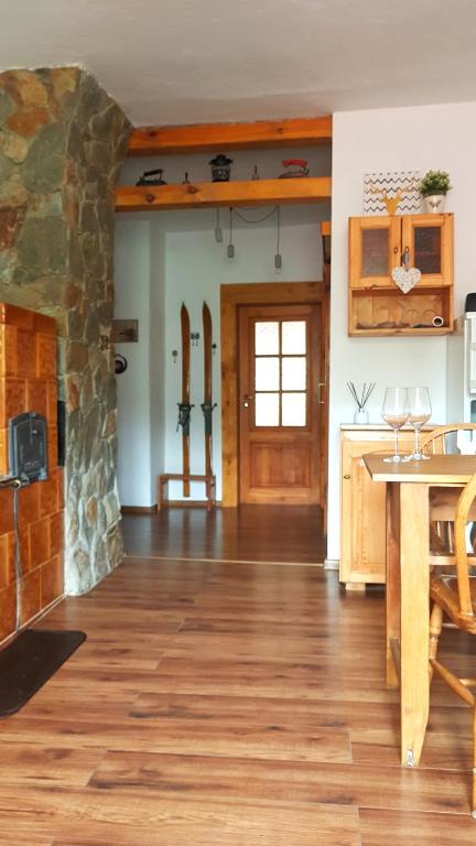 kuchnia z drewnianą podłogą i kamiennym kominkiem w obiekcie Klimatyczne Apartamenty Złoty Stok w Złotym Stoku