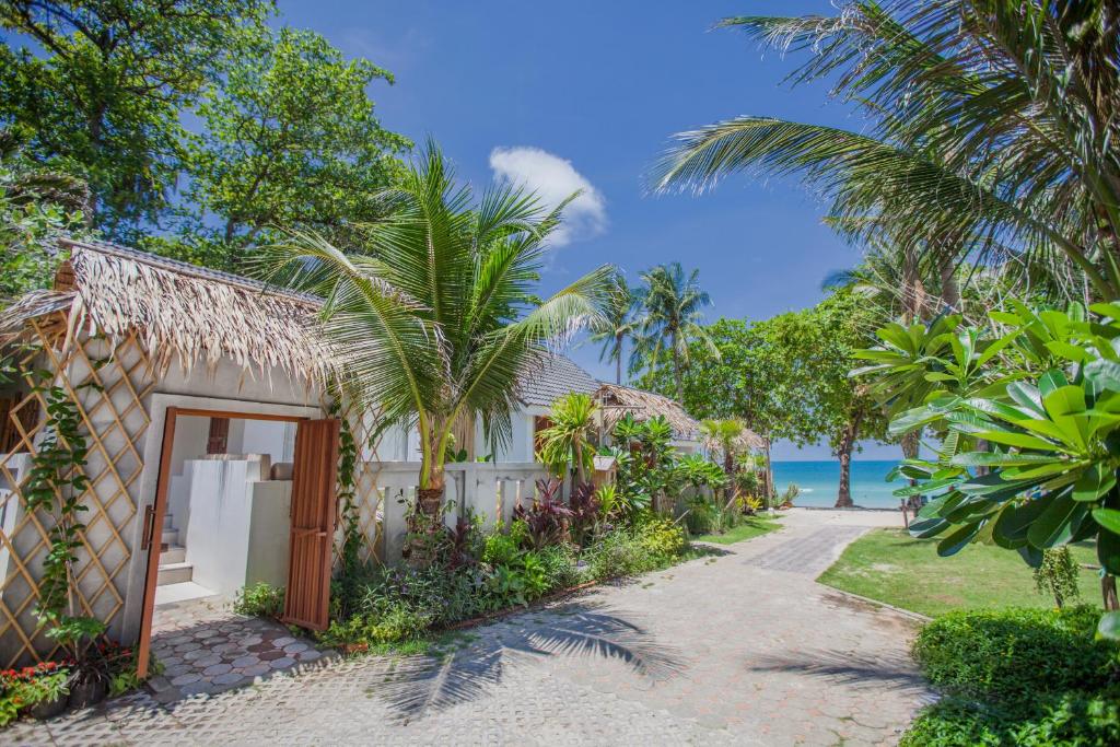 una cabaña en la playa con palmeras y una carretera en King's Garden Resort - SHA Plus, en Chaweng